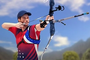 Kasketli bir adam, kırmızı-mavi spor kıyafetiyle açık havada ok ve yayla nişan alırken
