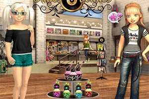 Gözlük ve şort giymiş beyaz saçlı bir kız ile tişört ve kot pantolon giymiş kız, bir mağazada cupcake tezgahının önünde duruyor