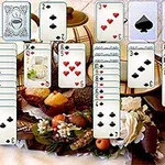 Farklı kart destelerini içeren bir ekran görüntüsü ön planda ve arka planda meyve ve çiçeklerle süslenmiş bir masa yer alıyor
