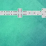 Yeşil arka plan üzerinde sırayla dizilmiş beyaz domino taşları