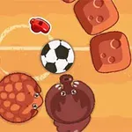 Kumlu bir zeminde futbol topuyla oynayan iki sevimli hayvan ve çevresinde bloklar