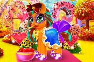 Renkli ve süslü bir pony, arka planda çiçeklerle çevrili bir bahçede, önünde bir kase elma ile duruyor