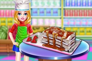 Mavi gözlü, sarı saçlı bir kız, üzerinde çilekler ve sos bulunan bir pasta ile birlikte mutfakta poz veriyor