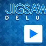 Mavi zemin üzerinde büyük beyaz bir oyun başlatma düğmesi ve Jigsaw Deluxe yazısı