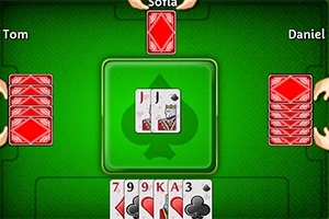 Yeşil bir masa üzerinde ortadaki kare alanda iki adet yüzleri açık kart, çevresinde ise isimlerle belirtilmiş oyuncuların kapalı kart desteleri ve alt kısımda beş adet açık kart bulunmaktadır