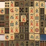Bir göl manzarasının önünde, üzerinde çeşitli semboller ve karakterler bulunan Mahjong taşları dizilimi
