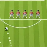 Yeşil çim üzerinde duran futbol topu ve kırmızı formalı beş futbolcudan oluşan baraj