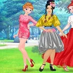 Üç genç kadın, renkli elbiselerle ormanlık bir parkta poz veriyor